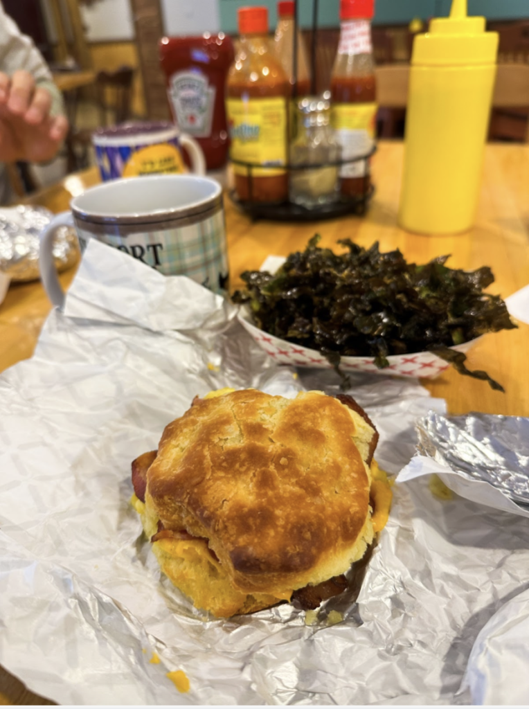 a large breakfast sandwich with bacon, egg, and cheese on a biscuit