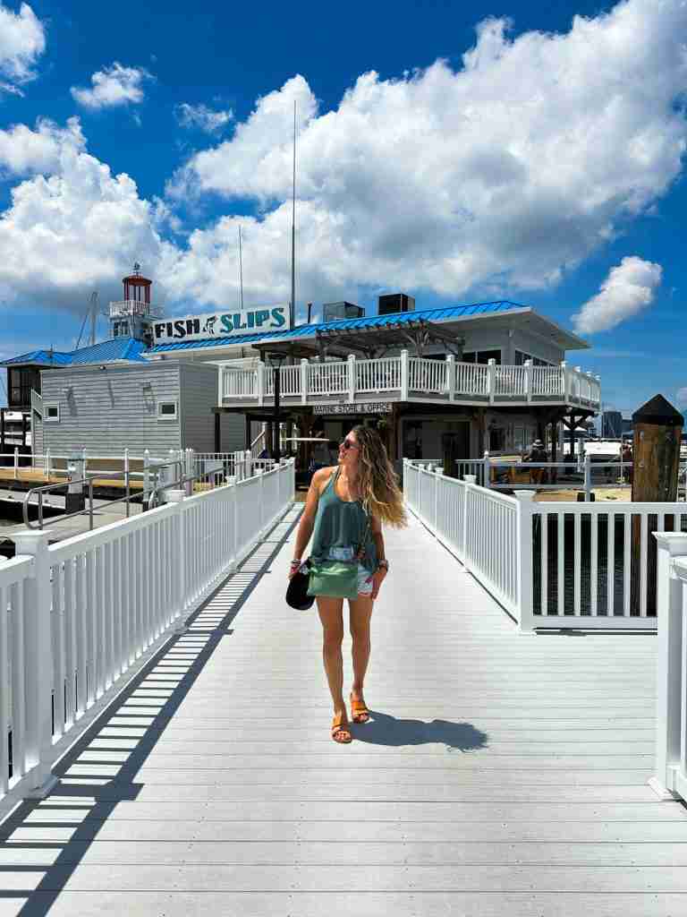 a girl walks on the board walk at the harbor in Portsmouth VA