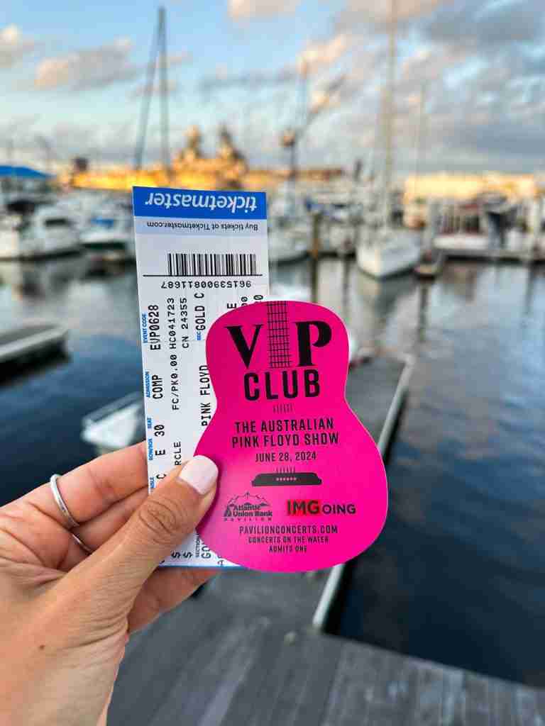 a girl holds up tickets to an outdoor music concert in Portsmouth VA