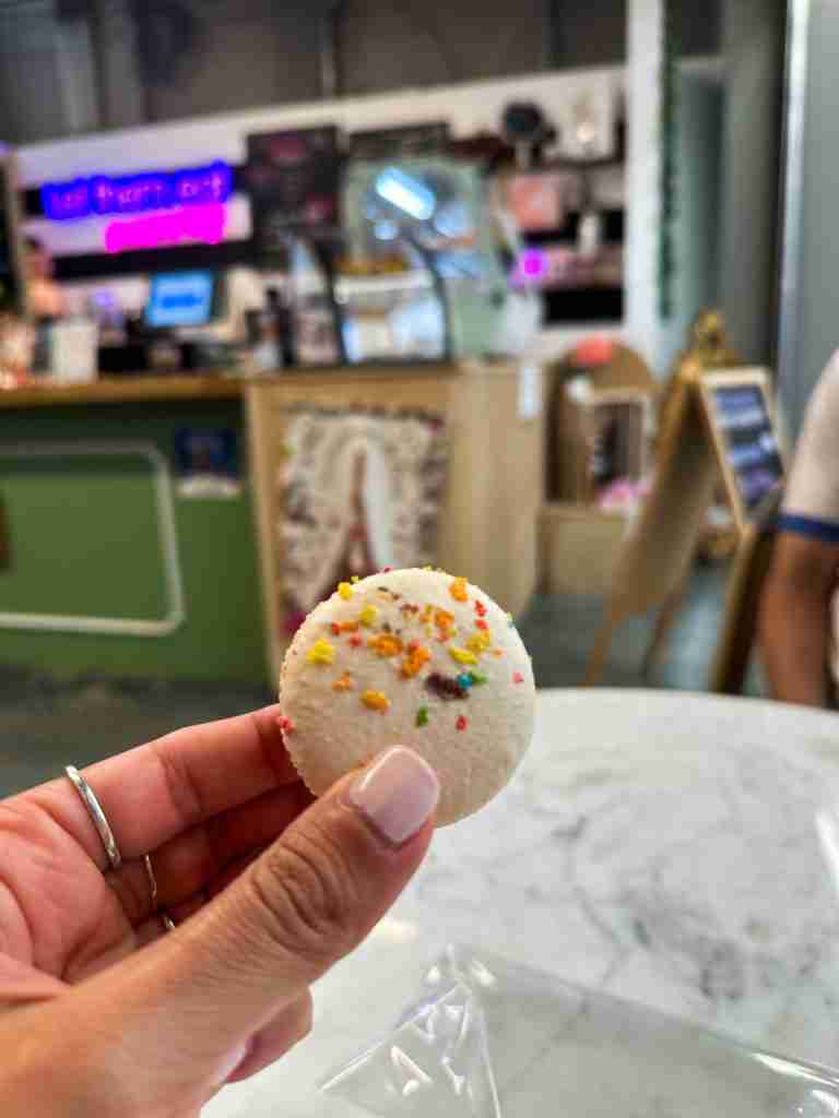 girl holds a French macaron at a bakery in Portsmouth VA
