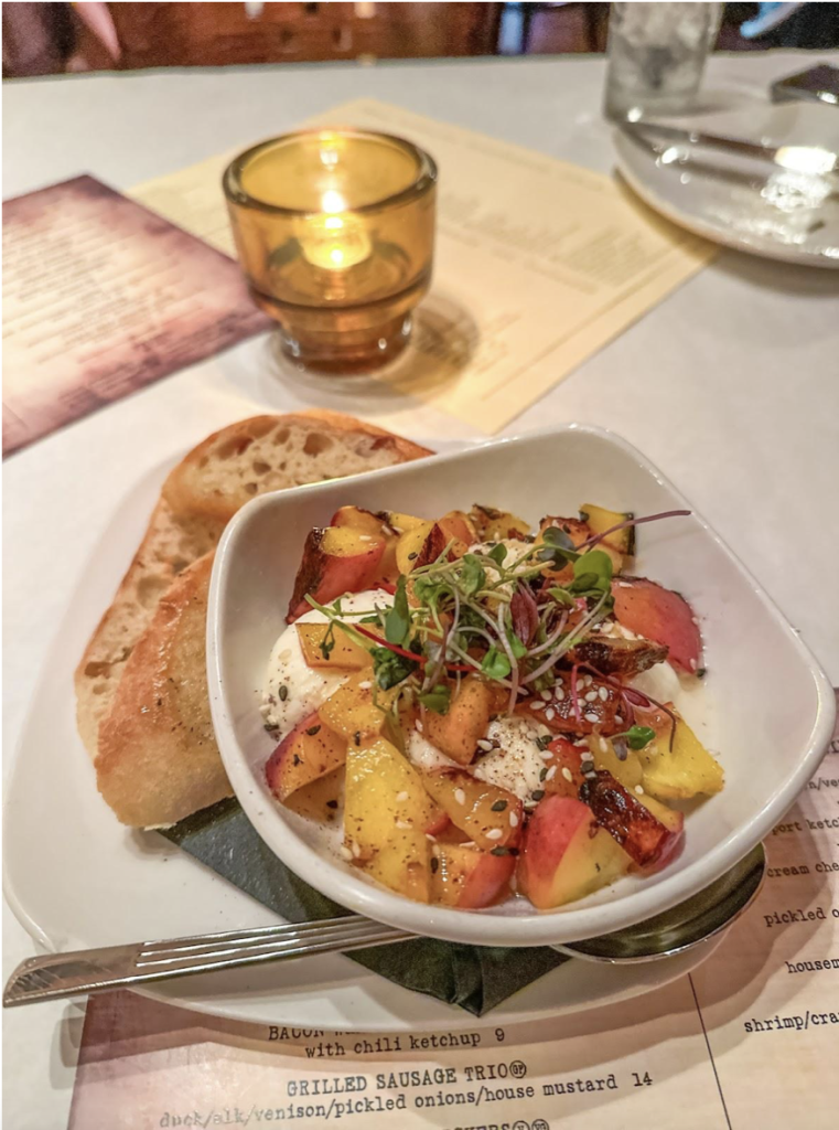 a bowl of peach buratta and side of bread at a restaurant in Portsmouth VA